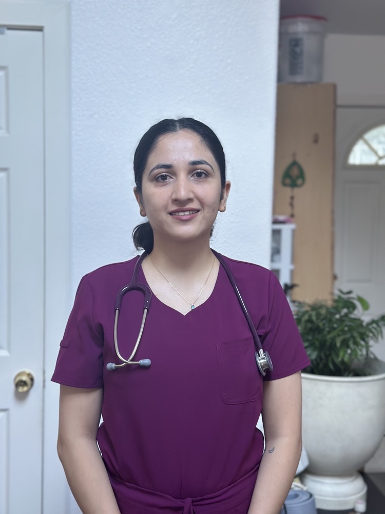 Asmita Baskota, registered nurse, in scrubs with a stethoscope